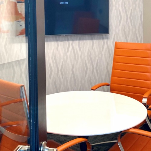 Coworking Space Small office with four person table and hanging TV.